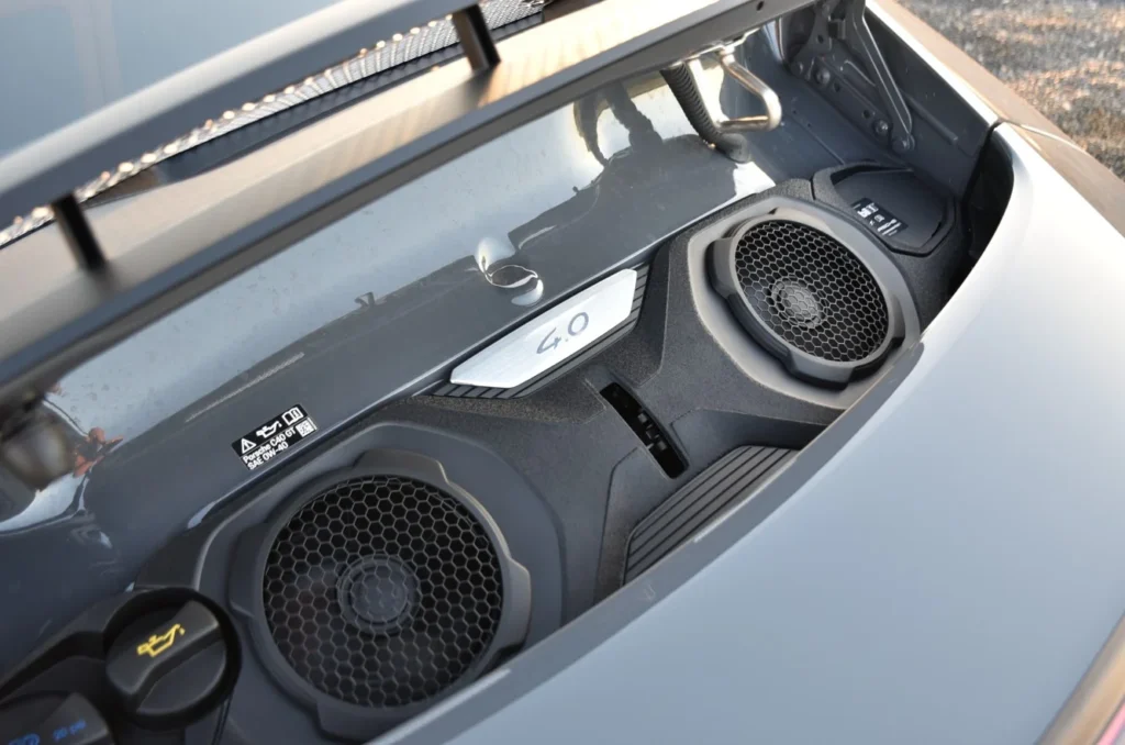 Open front trunk of a sports car showing two circular speaker grilles and a 4.0 badge.